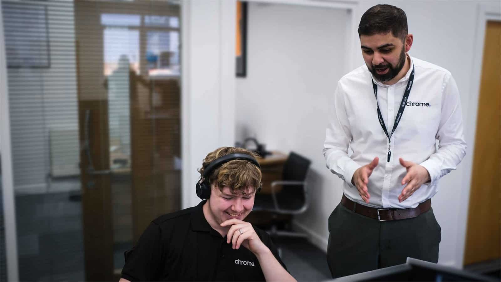 Ali and Kallum from the Chrome Telecom technical team working together at their desks, supporting cloud services