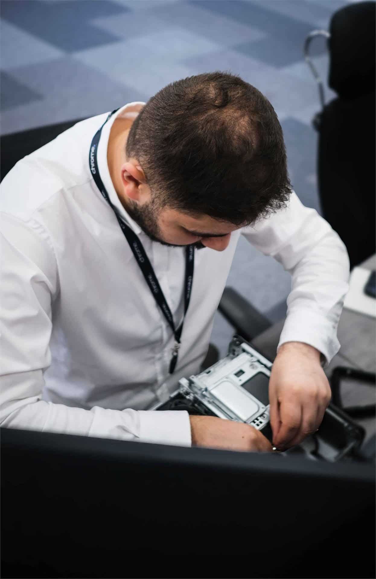 Ali carrying out hardware repairs on a desktop PC, supporting cloud services