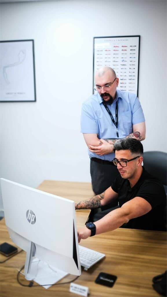 Chrome Telecom colleagues talking at a desk in the office, supporting cyber security