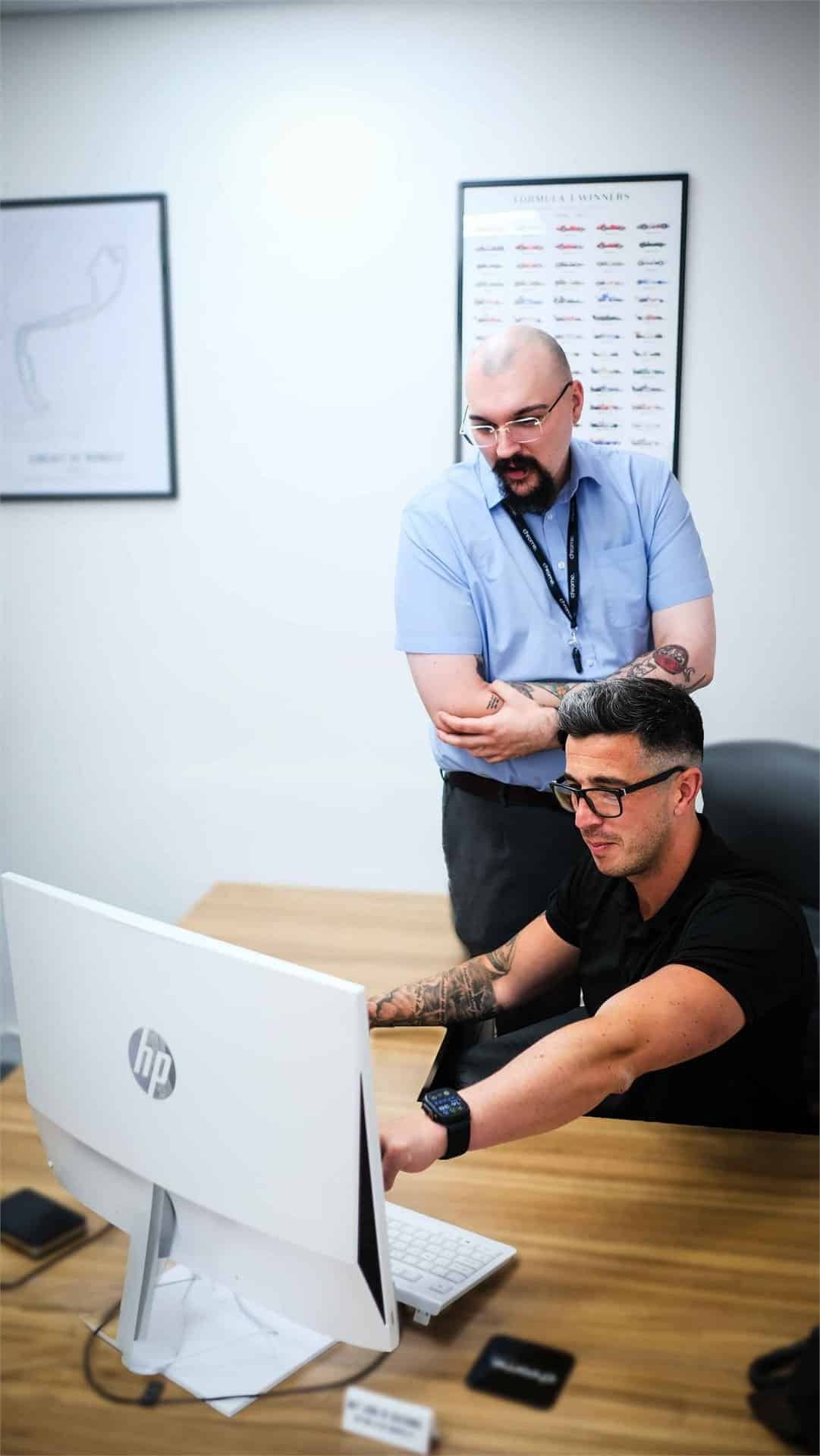 Chrome Telecom colleagues talking at a desk in the office, supporting cloud services