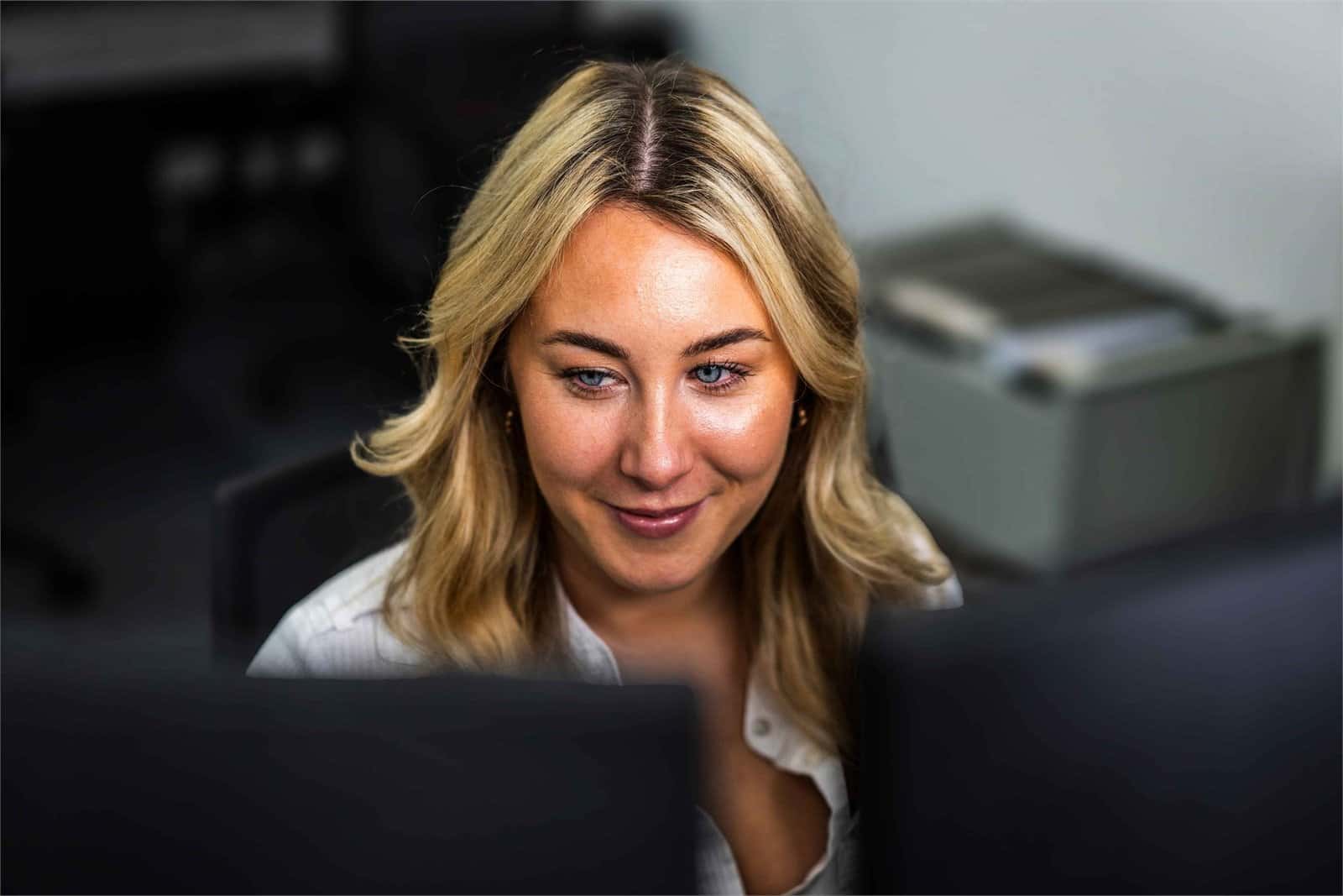 Chloe working at her desk in the Chrome Telecom office, supporting security