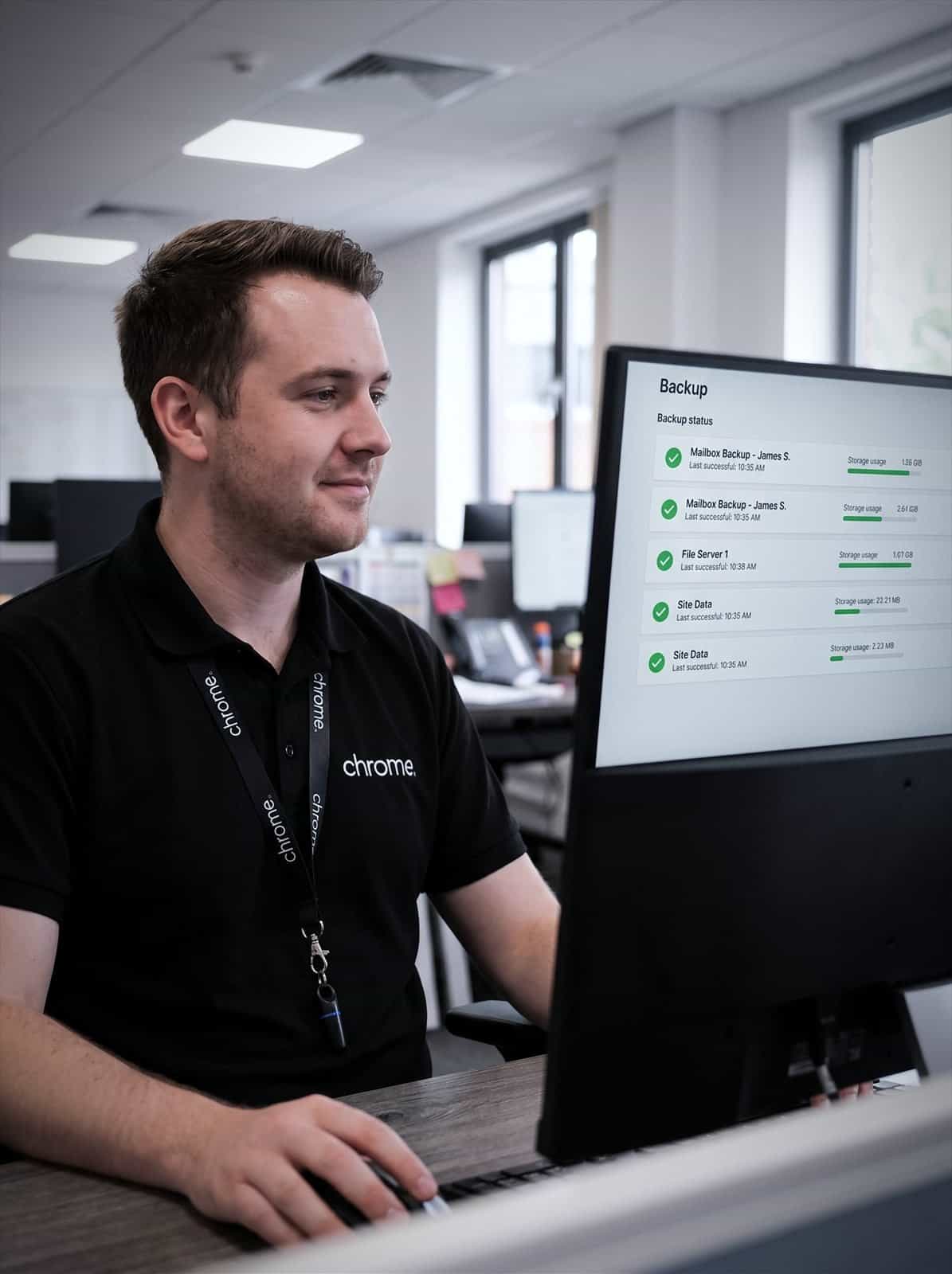 A Chrome Telecom colleague checks a Microsoft 365 backup status list showing completed jobs