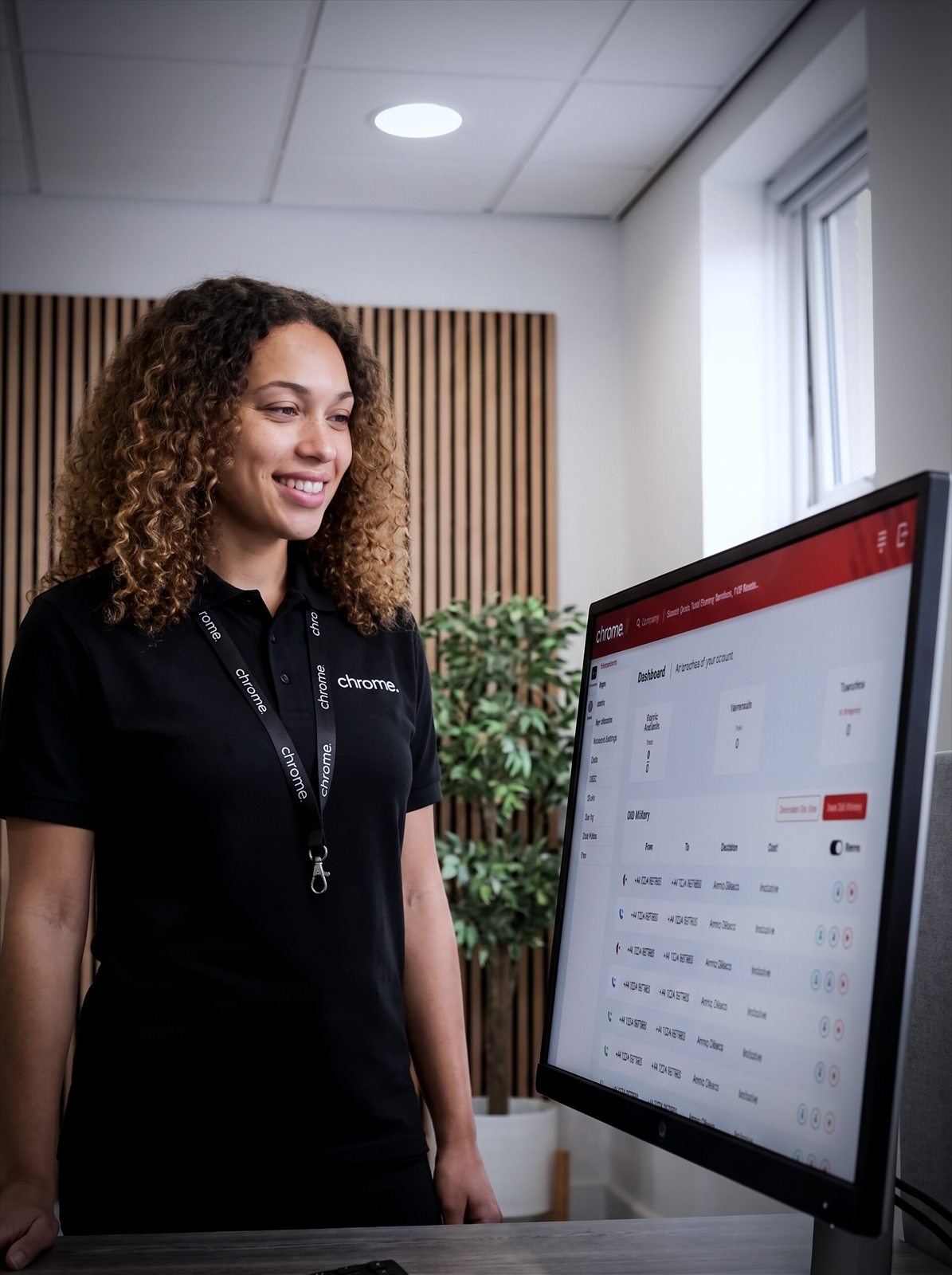 A Chrome Telecom colleague reviews an analytics dashboard at her desk in the office