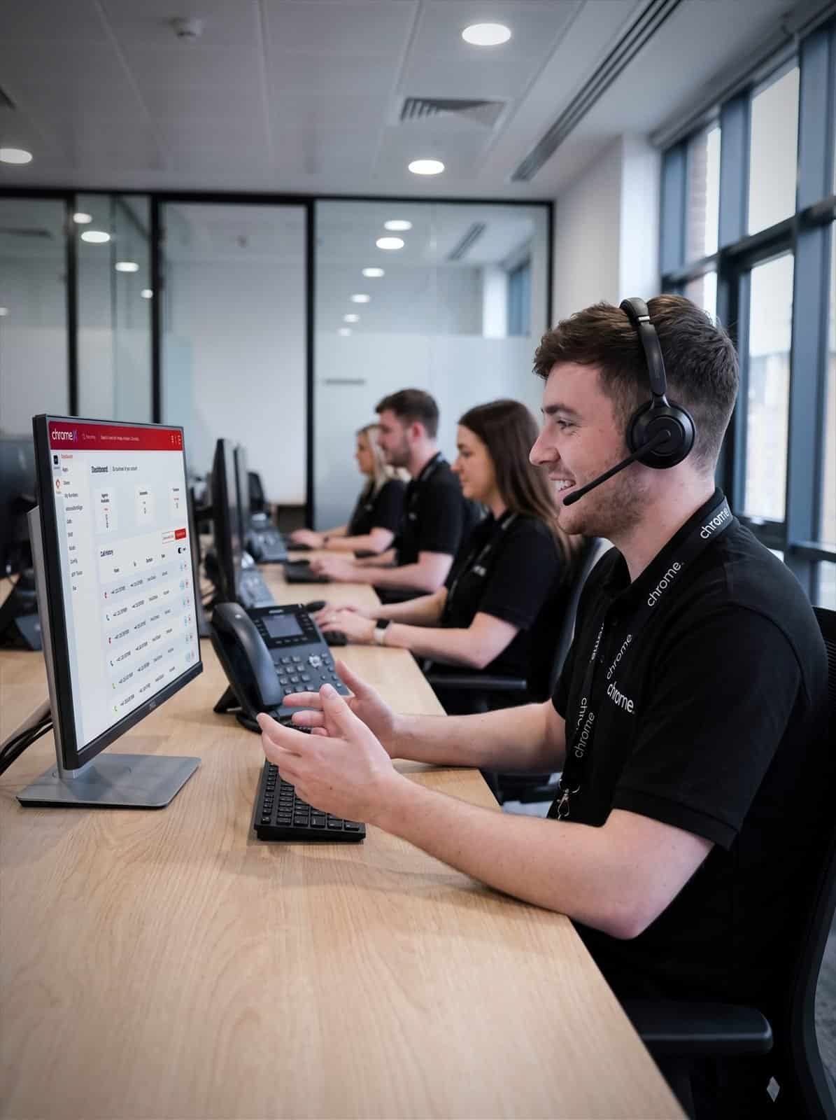 A Chrome Telecom advisor on a call with the wider support team working behind them