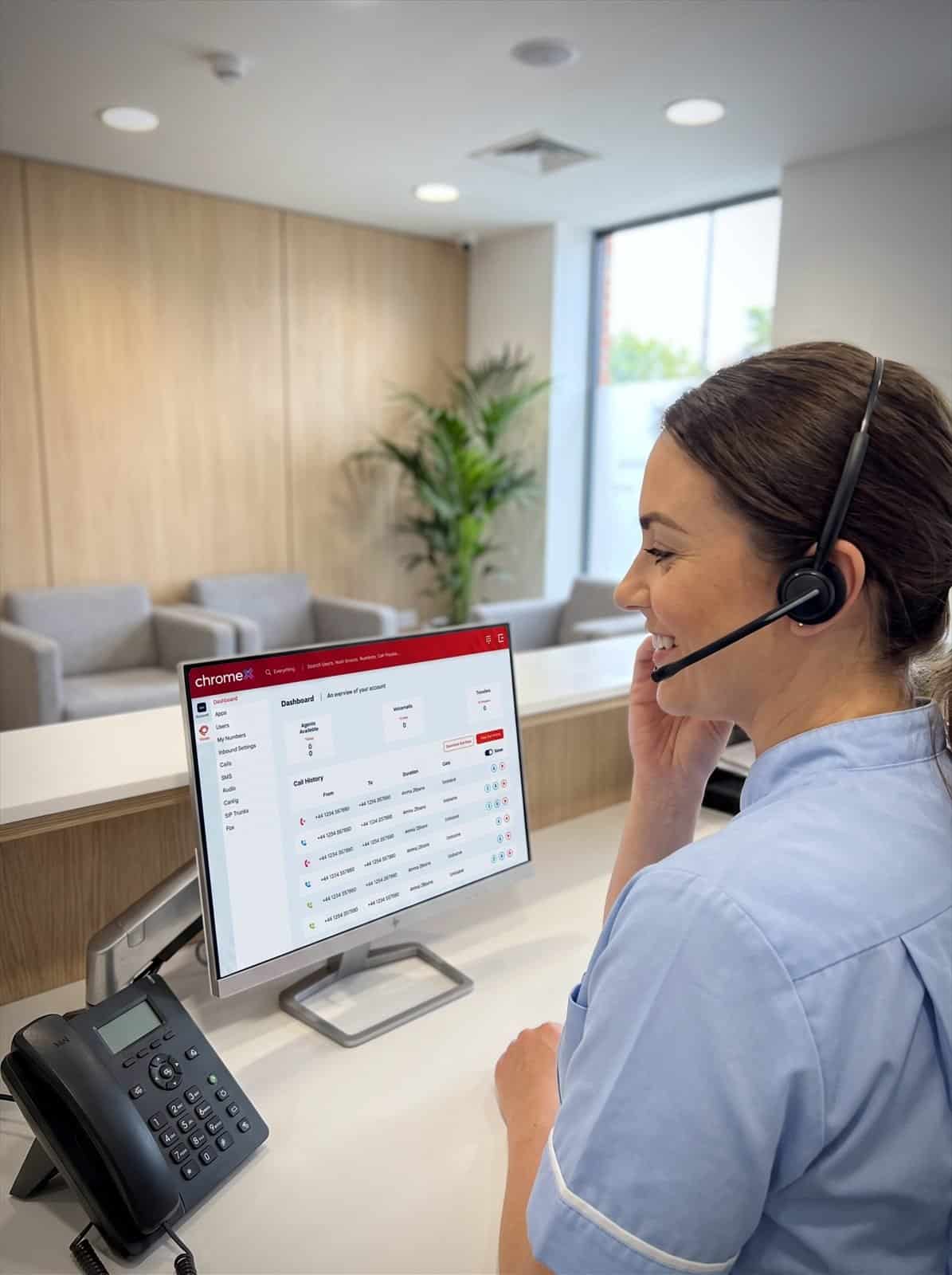 A dental practice receptionist takes a patient call at the front desk