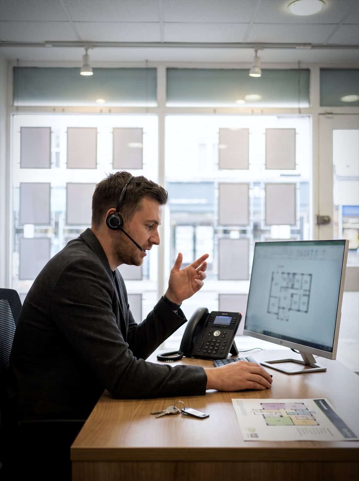 An estate agency negotiator takes a buyer call at the branch