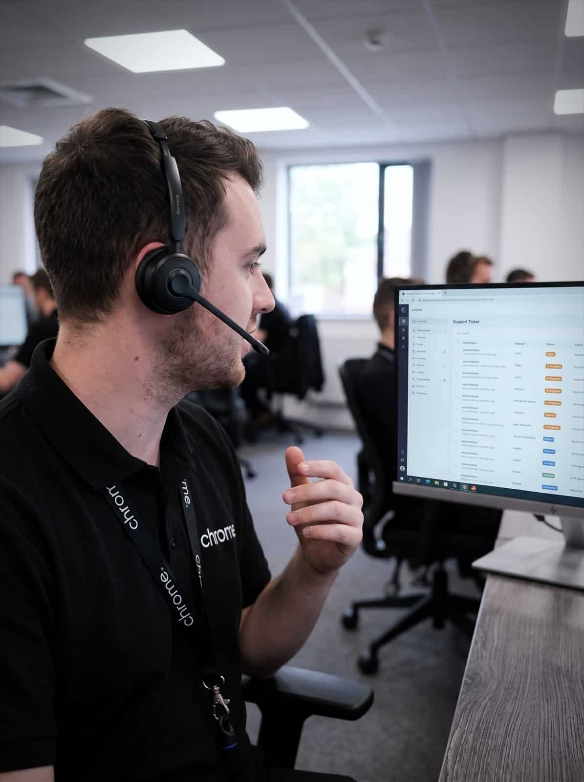 A Chrome Telecom helpdesk technician talks a caller through a fix with the support ticket queue on screen