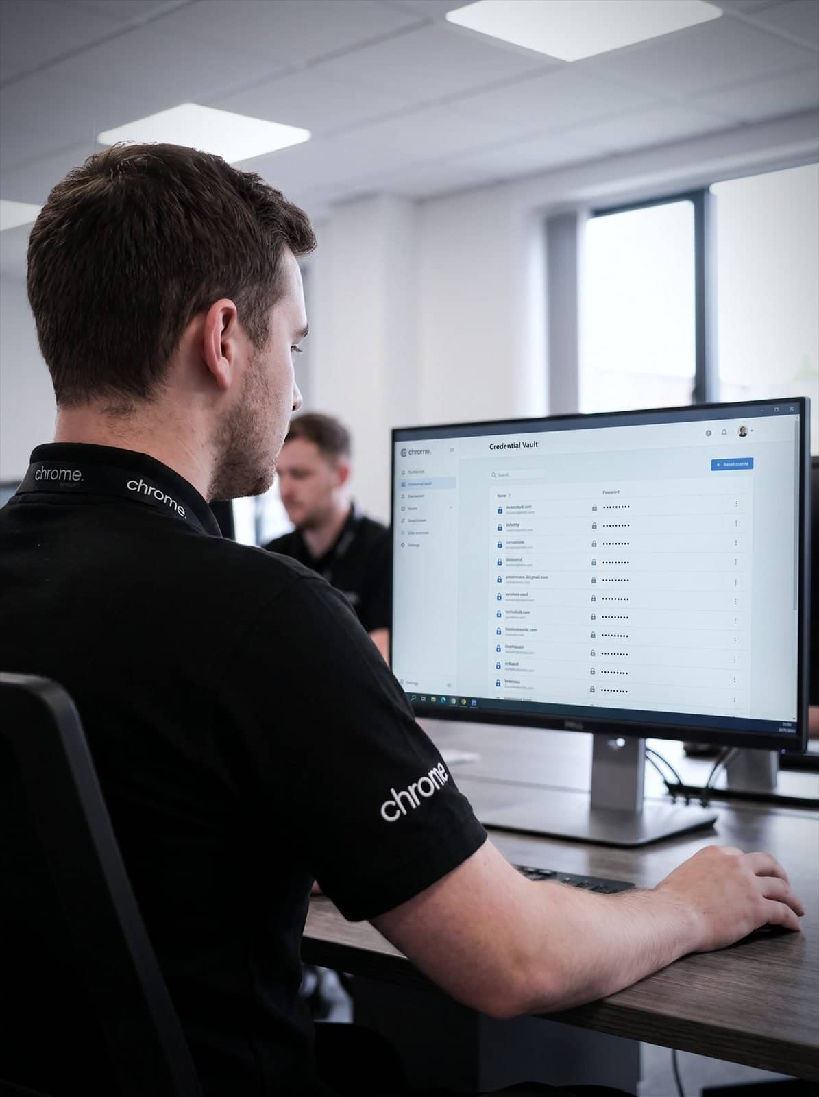 A Chrome Telecom colleague reviews a secure credential vault with masked entries on screen