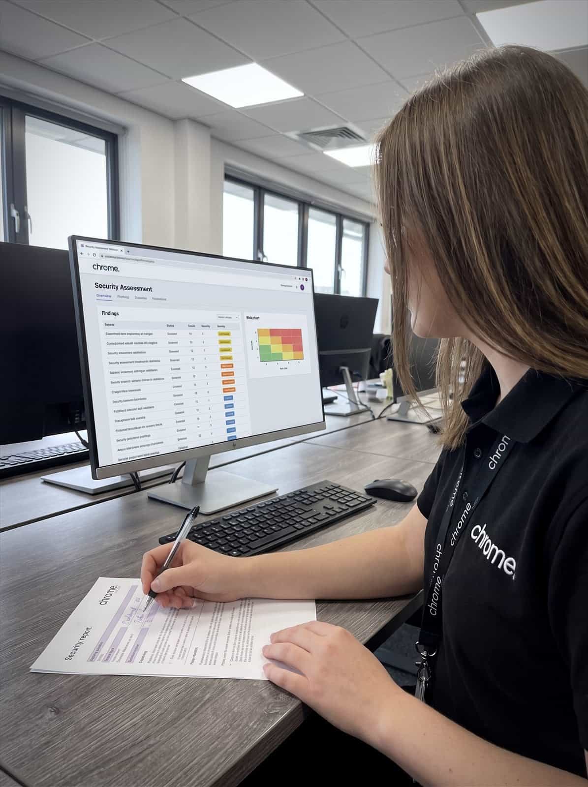 A Chrome Telecom tester works through security assessment findings on screen alongside a printed report