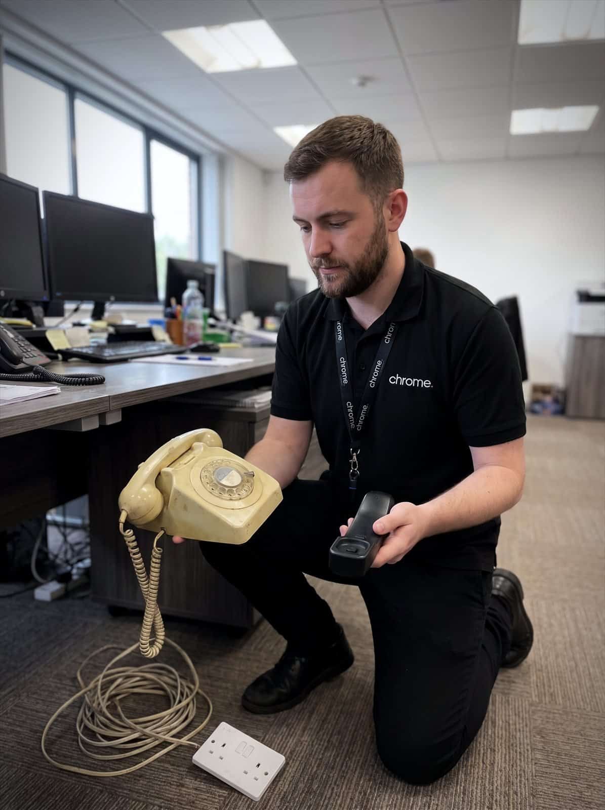 A Chrome Telecom engineer compares an old analogue telephone with a modern VoIP handset