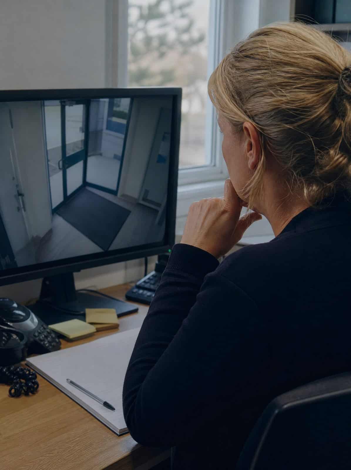 A GP practice manager reviews a security camera monitor
