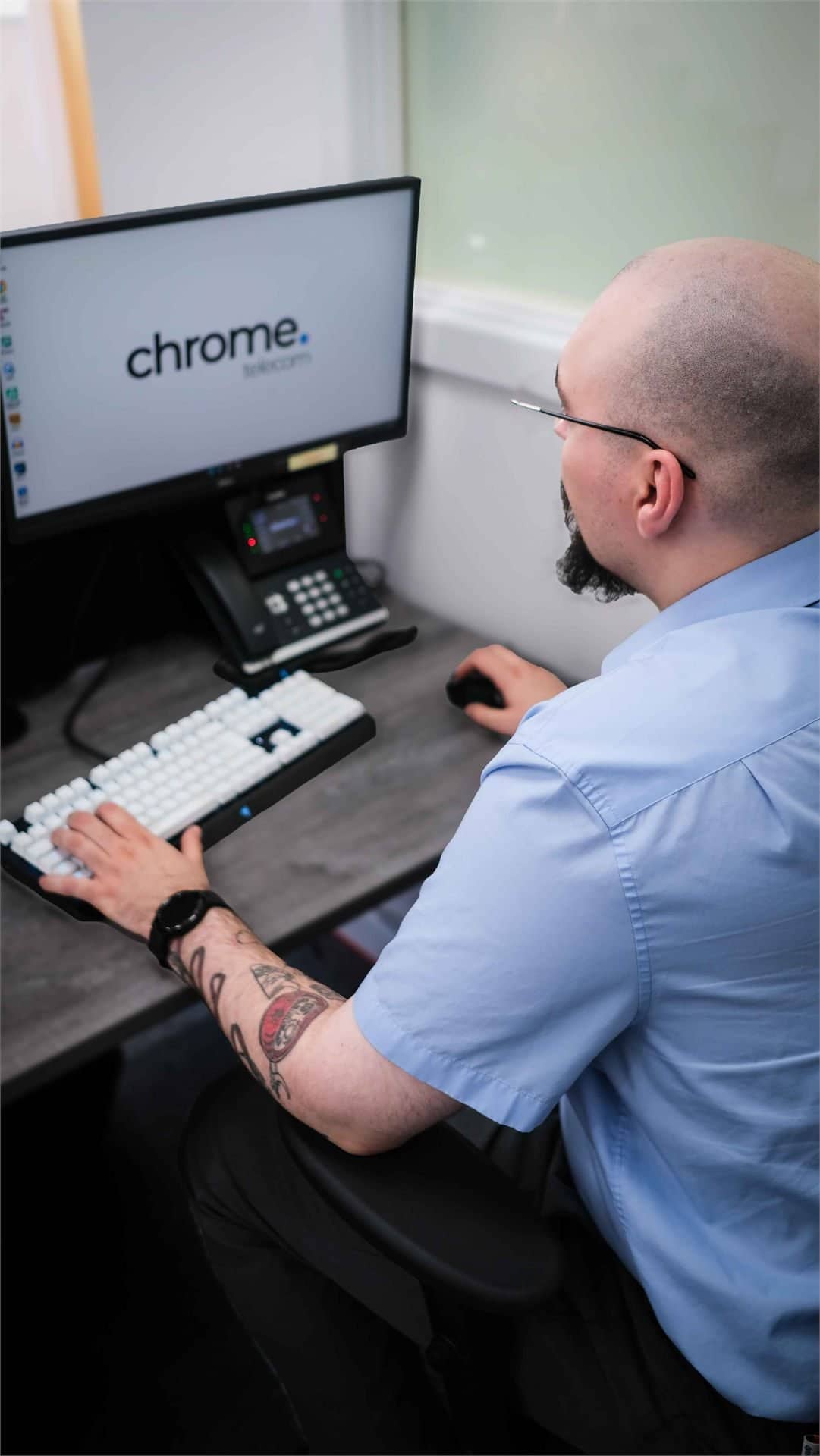 Jake at his workstation with dual monitors, supporting security