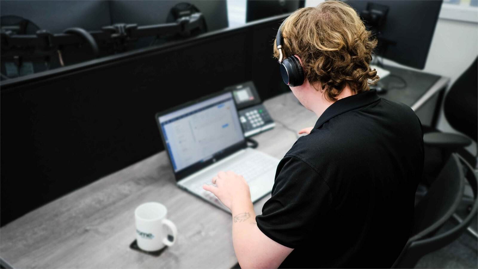 Kallum working at his computer, supporting virtual desktops