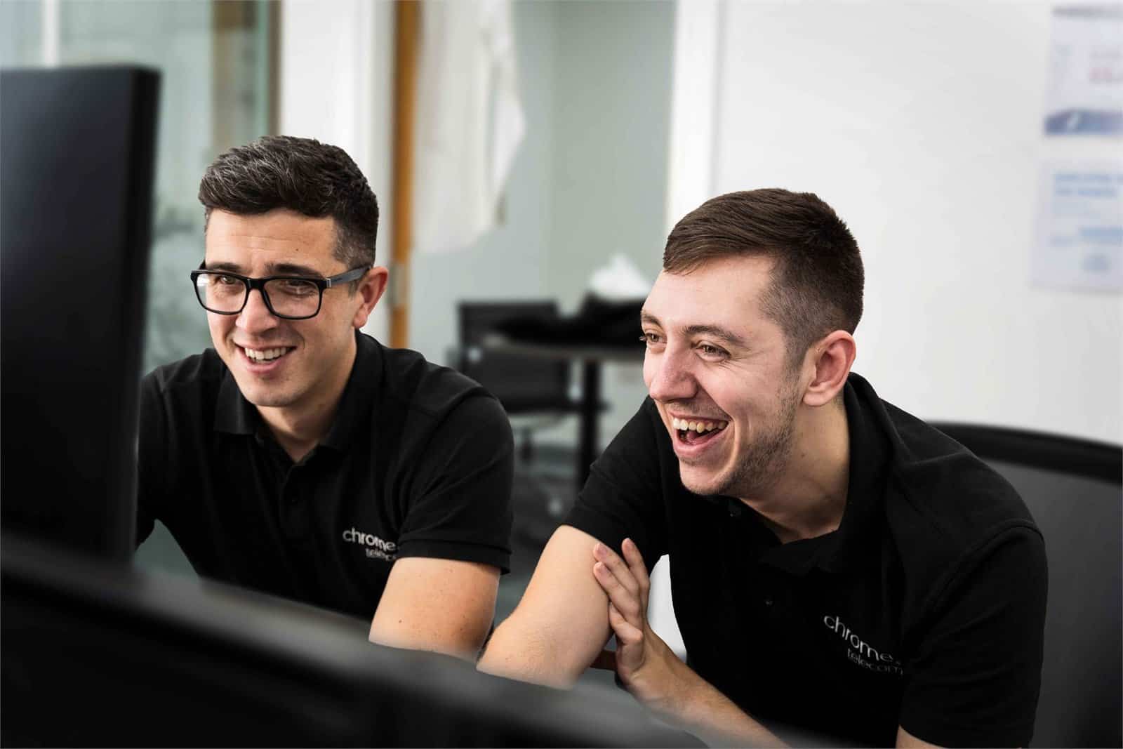 Matt and Cameron working together at a desk, supporting Microsoft 365