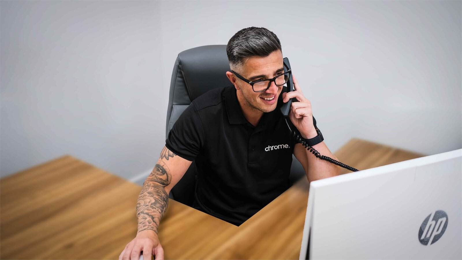 Matt taking a call at his desk, supporting phone system features