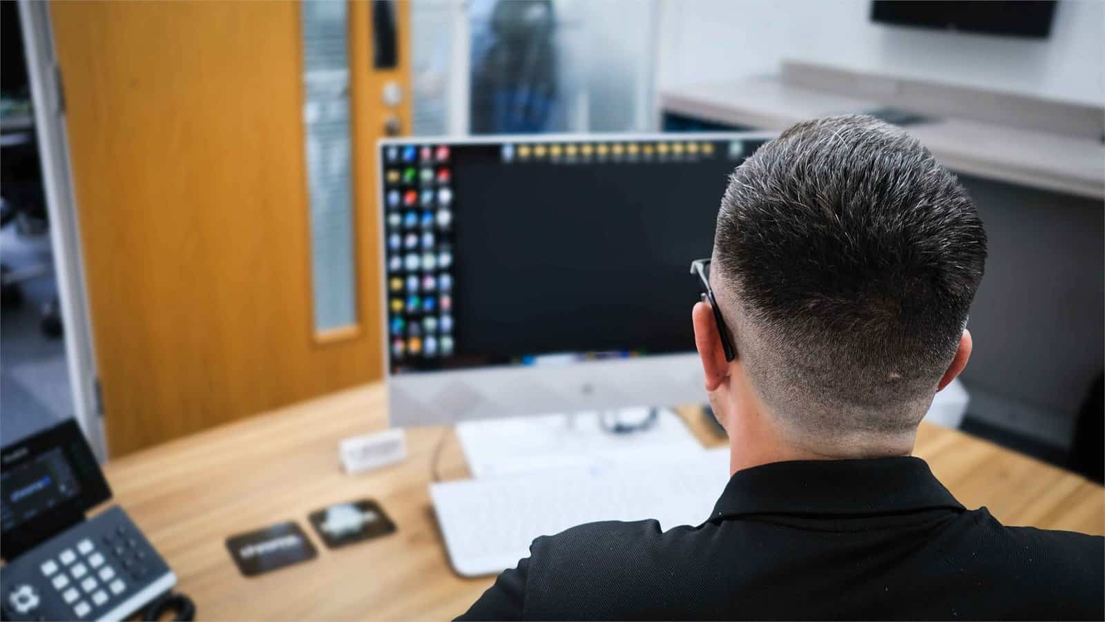 Matt concentrating on his screen while working, supporting phone system features