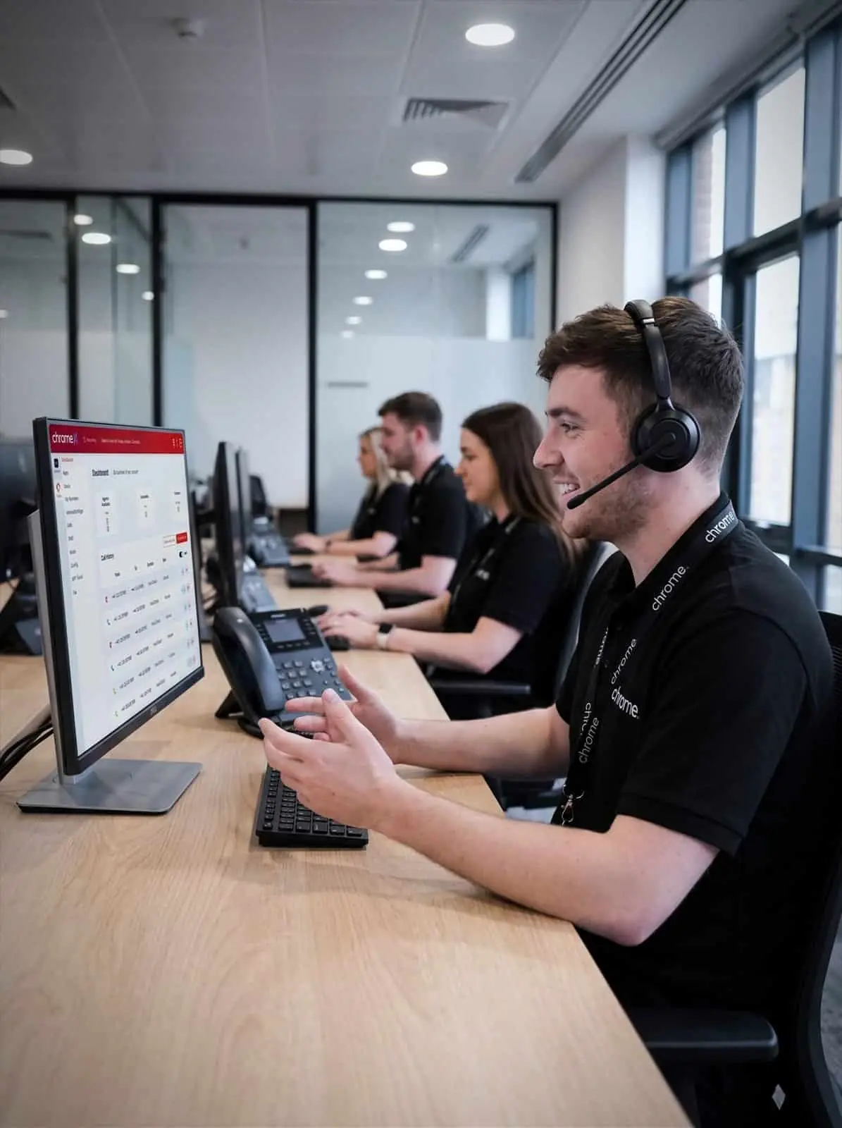 A Chrome Telecom advisor on a call with the wider support team working behind them