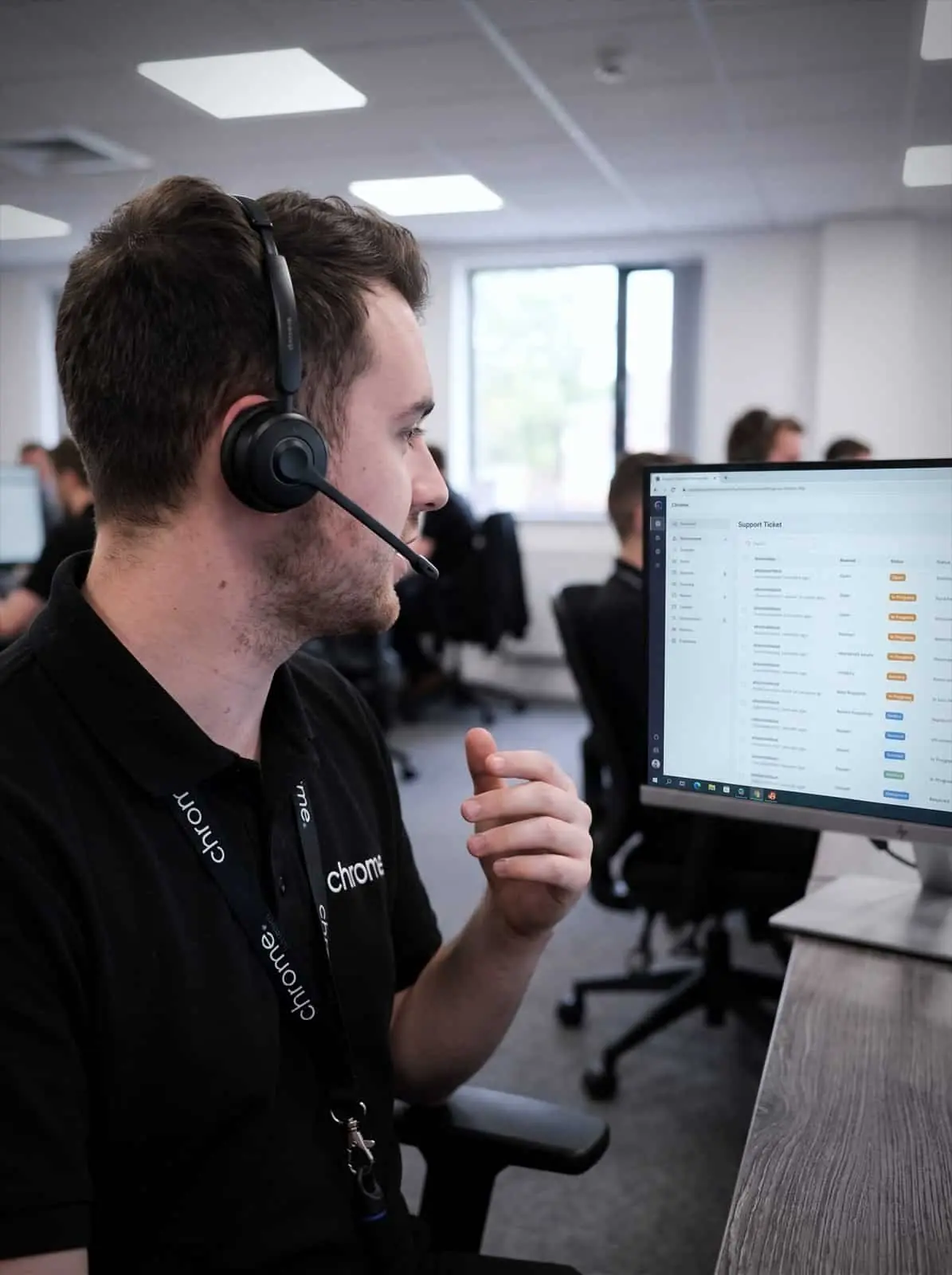 A Chrome Telecom helpdesk technician talks a caller through a fix with the support ticket queue on screen